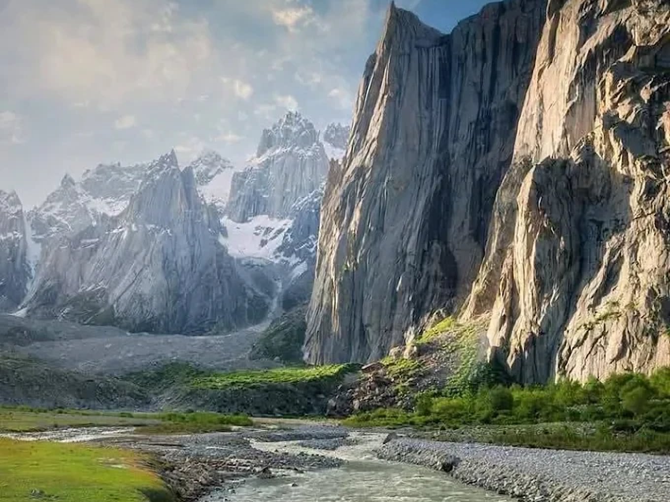 Towering granite walls and snowy spires above Nangma Valley, with green slopes and a river below